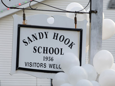 Balloons hang on a sign at the entrance to Sandy Hook School in Newtown, one day after a gunman killed 20 students and six educators. (File photo by Don Emmert/Getty Images)