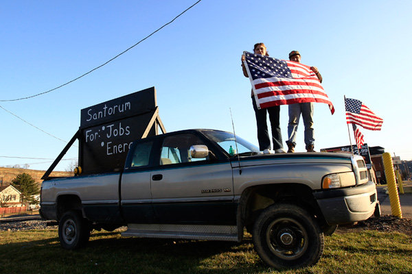 Rick Santorum supporters hold the U.S. flag as they stand on a truck outside the site of the candidate's "Super Tuesday" primary party in Steubenville, Ohio.