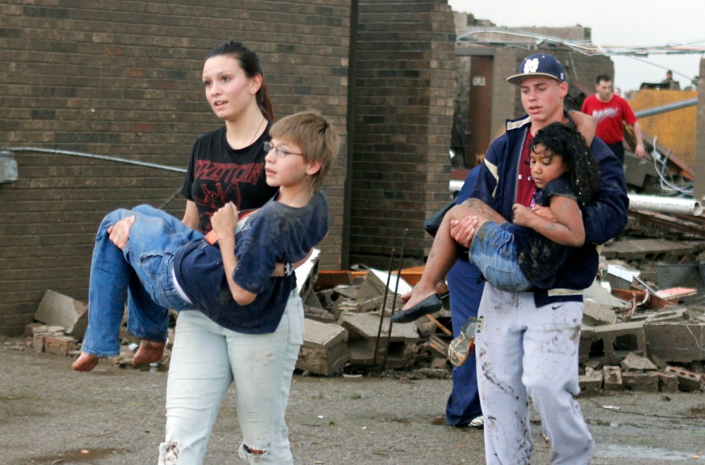 Teachers carry children away from Briarwood Elementary school after a tornado destroyed the school in south Oklahoma City, Okla, Monday, May 20, 2013. Near SW 149th and Hudson. (AP Photo/ The Oklahoman,  Paul Hellstern)