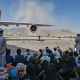 Afghans wait to leave the airport in Kabul on Aug. 16, 2021.