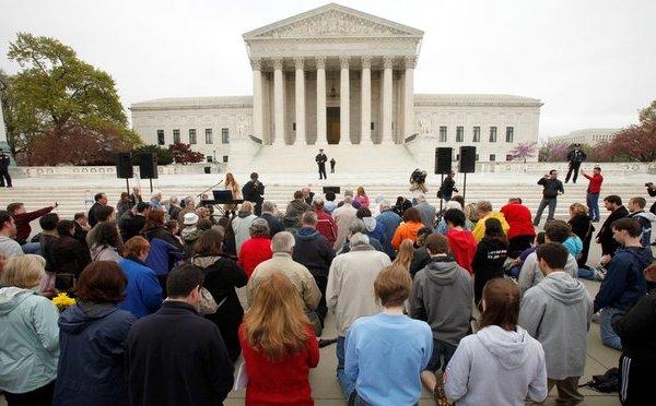 Conservative opponents of 'Obamacare' prayed outside the Supreme Court yesterday.