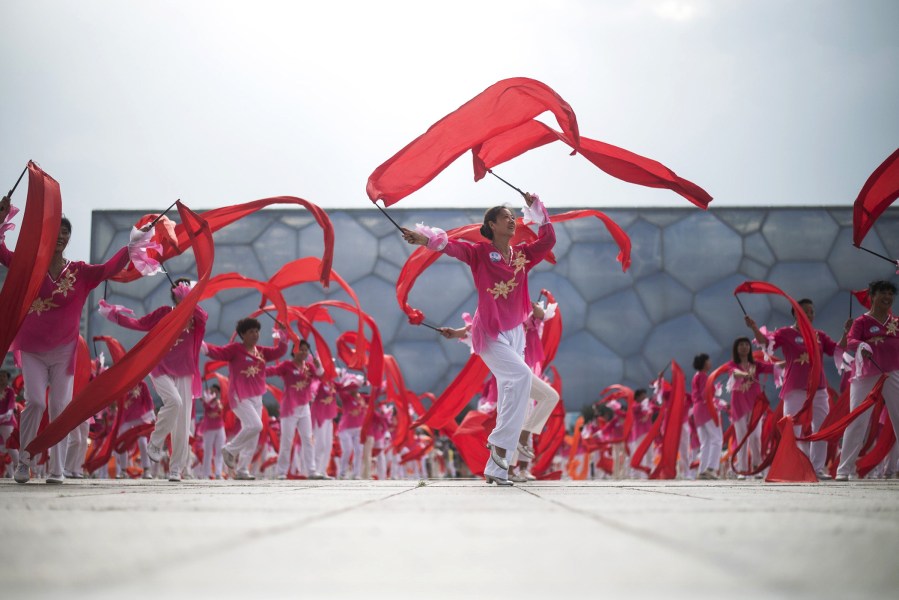 Volunteers parade in front of journalists a few minutes before the announcement by the International Olympic Committee voting for Beijing to host the 2022 Winter Olympics in Beijing on July 31, 2015. (Photo by Fred Dufour/AFP/Getty)