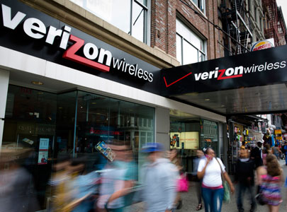 Pedestrians pass a New York City Verizon Wireless store on June 6, 2013. (Photo by John Minchillo/AP)