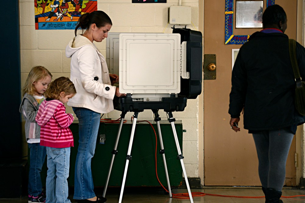 Ashley Zorman votes while her daughters Erica Zorman, left, and Keira Zorman, look on at Little Creek Elementary School in Norfolk, Va. on Tuesday, Nov. 6, 2012.
