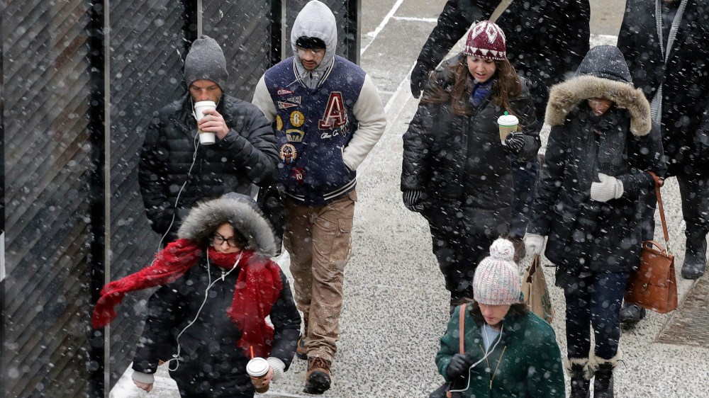 A light snow falls on pedestrians on Jan. 26, 2015 in New York.