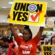 A woman holds a sign that says "Union Yes"