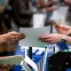 An attendee hands a resume to a recruiter at a job fair hiring event in Sacramento, Calif., on Feb. 27, 2025.
