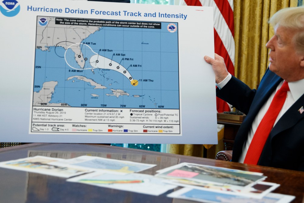 Donald Trump holds a NOAA map.