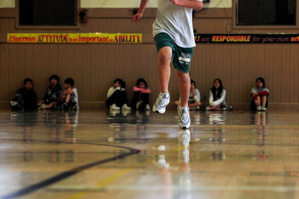 A student runs across the gym floor