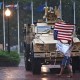 A protester is blown around in the rain as members of the D.C. National Guard take shelter in their vehicle outside Union Station in Washington