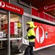 Image: A postman enters an Australia Post store