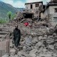 An man Afghan walks past a damaged house following earthquake.