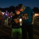People hold candles at a vigil.