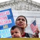 A person holds a sign that reads, "American Born Children Are American Children"
