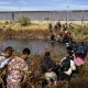 Migrants, predominantly from Venezuela, cross the Rio Grande