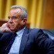 Robert F. Kennedy Jr sits with his hand under his chin