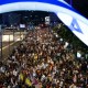 Demonstrators lift placards and flags during a protest in Tel Aviv, Israel.