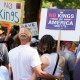 Activists carry signs during a "No Kings" protests.