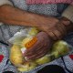 A woman holds a bag of pears as she waits in line to receive free food at the Richmond Emergency Food Bank.