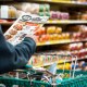 A shopper looks at a sales advertisement at a grocery store.