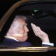 US President Donald Trump waving from his presidential car.