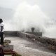 A man watches the waves crash into the walls at the Kingston Waterfront.