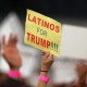 A woman hoods a sign expressing Latino support for Republican presidential candidate Donald Trump in Costa Mesa, CA.