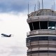 An American Eagle plane takes off near the air traffic control tower.