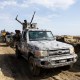 A Multinational Joint Task Force (MNJTF) military escort accompanying an excavator digging trenches passes through a checkpoint in Borno state, Nigeria.