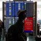 Travelers walk past the flight information display system at Los Angeles International Airport/