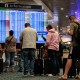 Passengers look at flight delays on a departure board at Orlando International Airport (MCO).