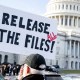 A protester holds a sign related to the release of the Jeffrey Epstein case files outside the Capitol.