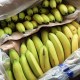 Bananas sit in a box at a fruit and vegetable store.