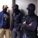 Federal agents wearing face coverings wait outside a courtroom.