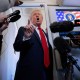 President Donald Trump talks to reporters on board Air Force One.