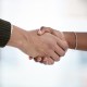 Closeup shot of two businesspeople shaking hands in an office.