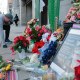 A jogger stops to pray at a makeshift memorial of flowers and American flags outside the Farragut West Metro station on Dec. 1, 2025, in Washington, D.C.