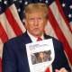 Then former U.S. President Donald Trump holds up a news story about New York Attorney General Letitia James as he speaks to the media at one of his properties at 40 Wall Street following closing arguments at his civil fraud trial on Jan. 11, 2024, in New York City.