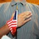 A person holds their hand up to their chest as they swear allegiance to the U.S. flag during a naturalization ceremony in Miami, F.L., on April 28, 2006.