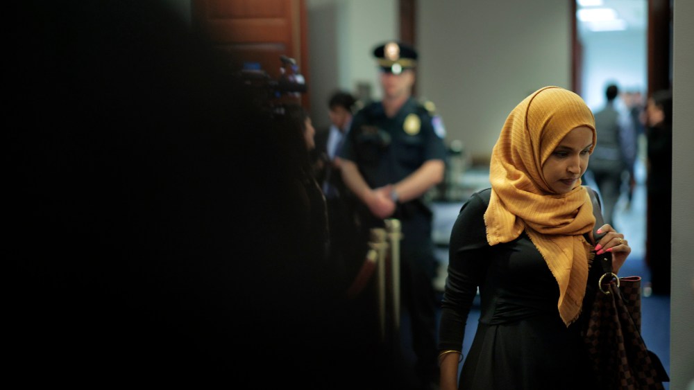 Rep. Ilhan Omar at the Capitol, with a police officer in the background.