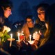People hold candles during a vigil for those injured and killed during the Saturday shooting at Brown University.