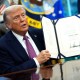 U.S. President Donald Trump holds up a signed act on Sept. 5, 2025, in the Oval Office of the White House.
