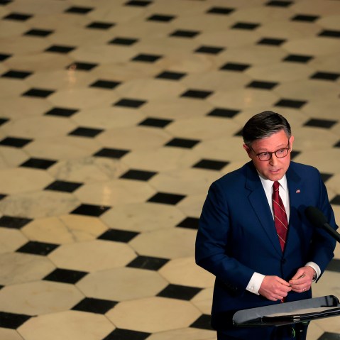 An aerial view of Speaker of the House Mike Johnson as he holds a news conference surrounded by the checkered floor of the Capitol.