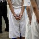 Accused gang members in handcuffs wait for a medical exam at the Counter Terrorism Confinement Center in Tecoluca, El Salvador.