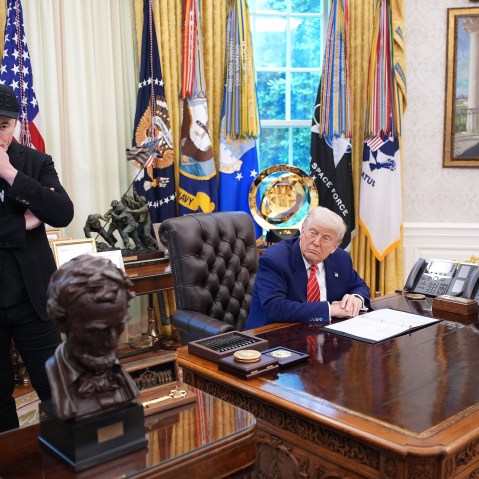 Tesla CEO Elon Musk and U.S. President Donald Trump listen to a question from reporters in the Oval Office.