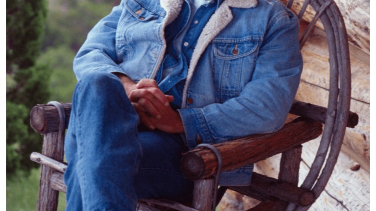 Jeffrey Epstein sits in a wooden porch chair.