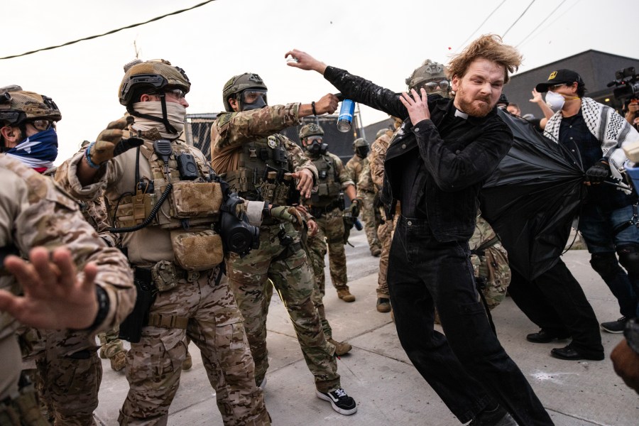 A federal immigration enforcement agent sprays Rev. David Black, of the First Presbyterian Church of Chicago, as he and other protesters demonstrate outside a U.S. Immigration and Customs Enforcement facility.