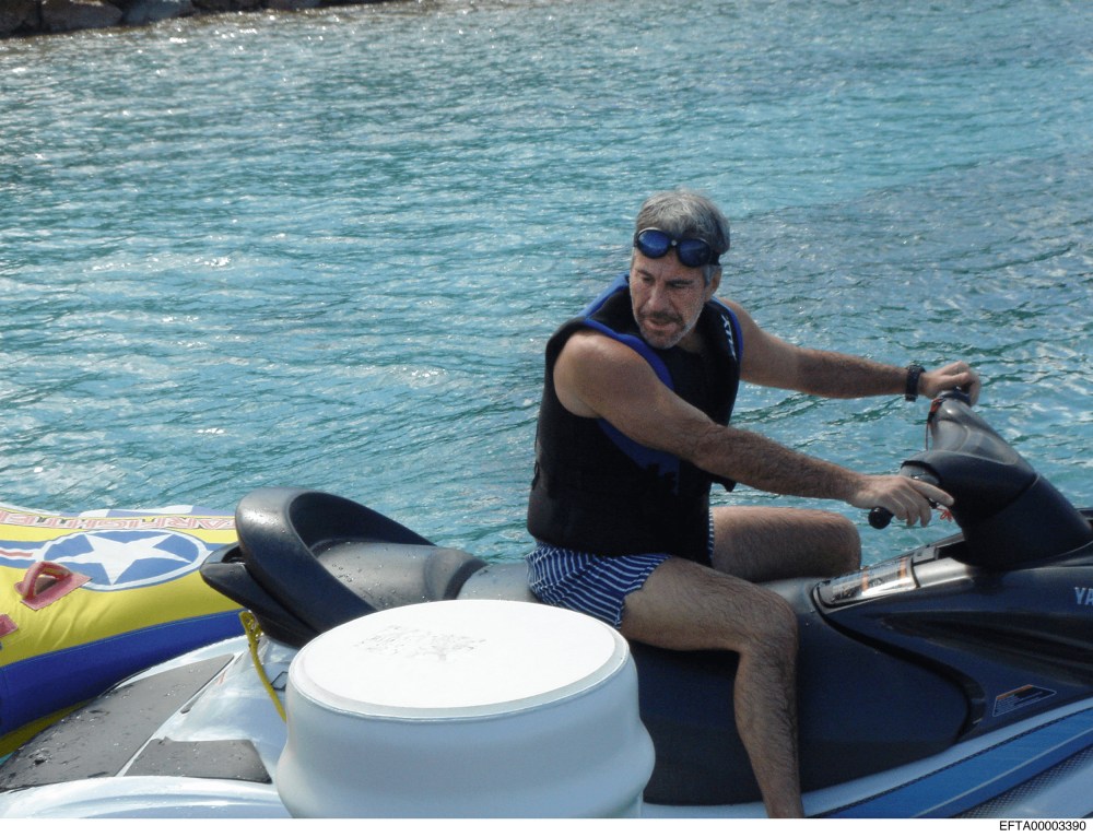 Jeffrey Epstein sitting on a jet ski by a dock.