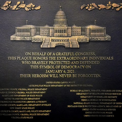 A plaque reads, "On behalf of a grateful Congress, this plaque honors the extraordinary individuals who bravely protected and defended this symbol of democracy on January 6, 2021. Their heroism will never be forgotten."