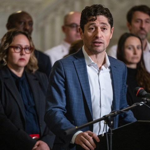 Jacob Frey speaks at a podium in front of other people.
